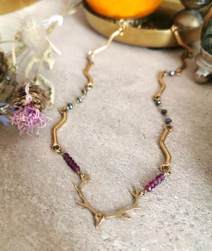 Collier à tête de cerf monté sur chaine articulée, plaquée or et pierres de grenat.
